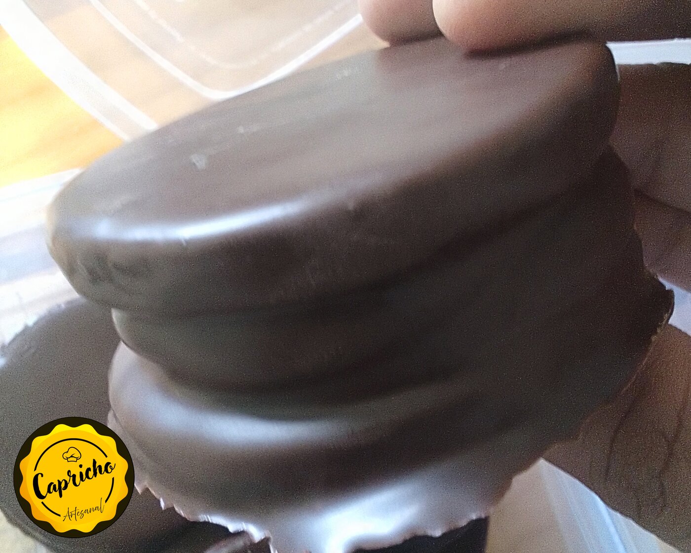 Detalle del baño de chocolate negro brillante de un alfajor Capricho